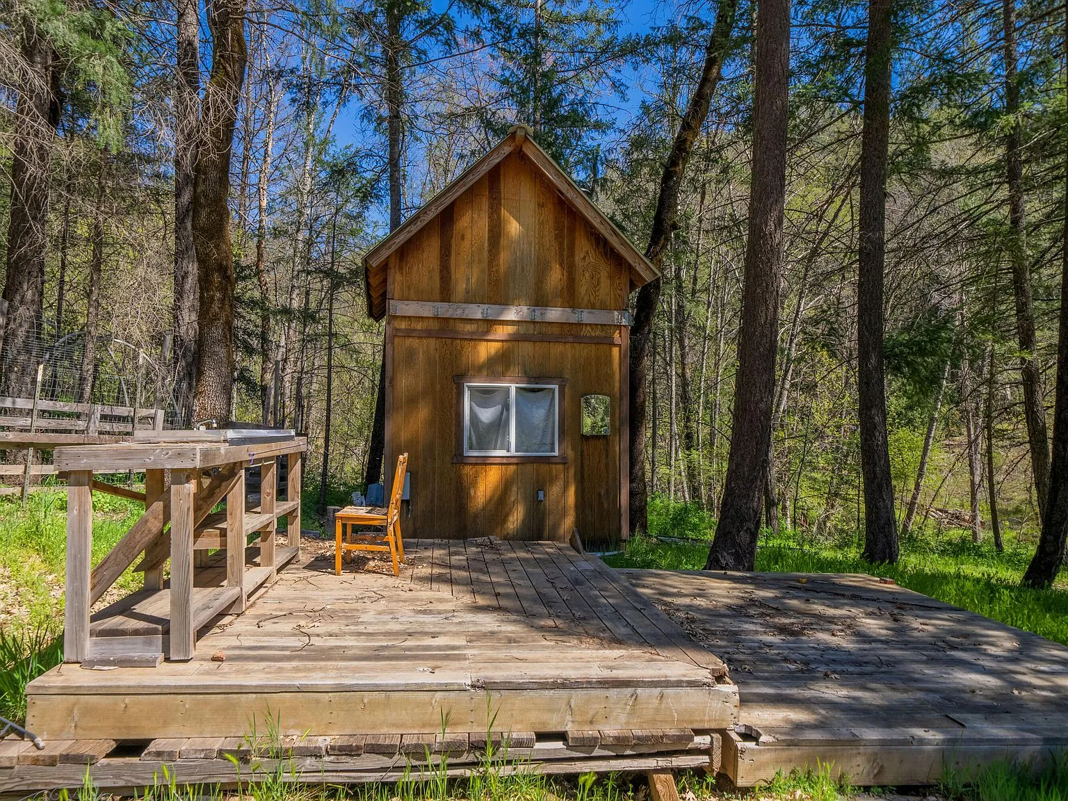 A second small outbuilding with a covered deck, tucked into the forest