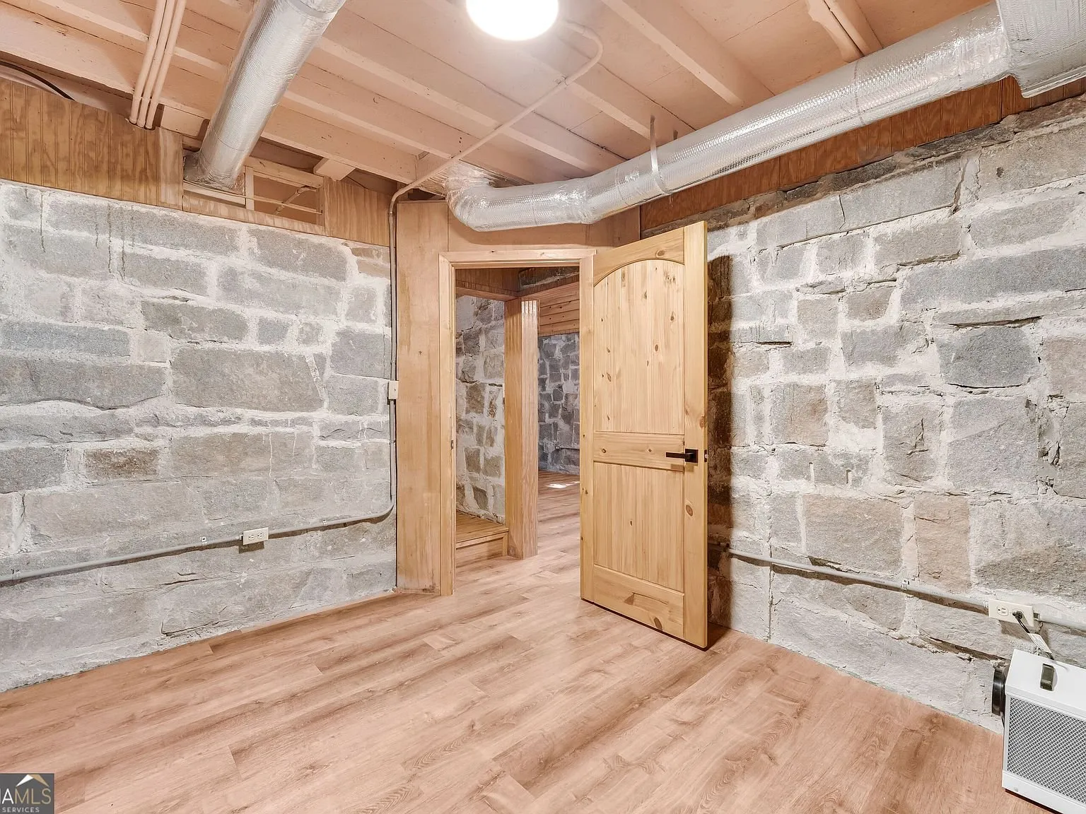 An unfinished storage area with exposed framing beneath the main level