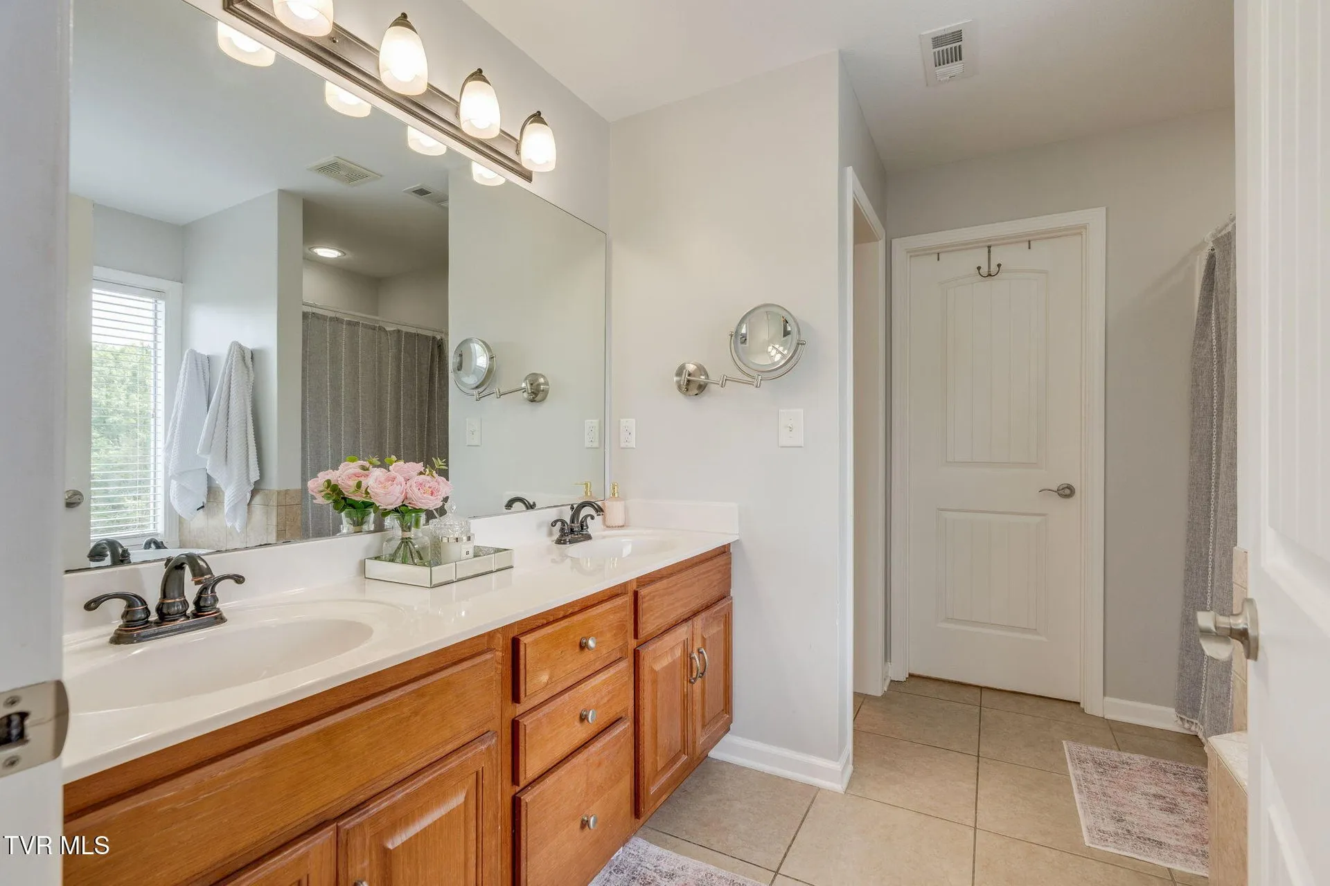 The primary bathroom with its long double vanity and wide mirror