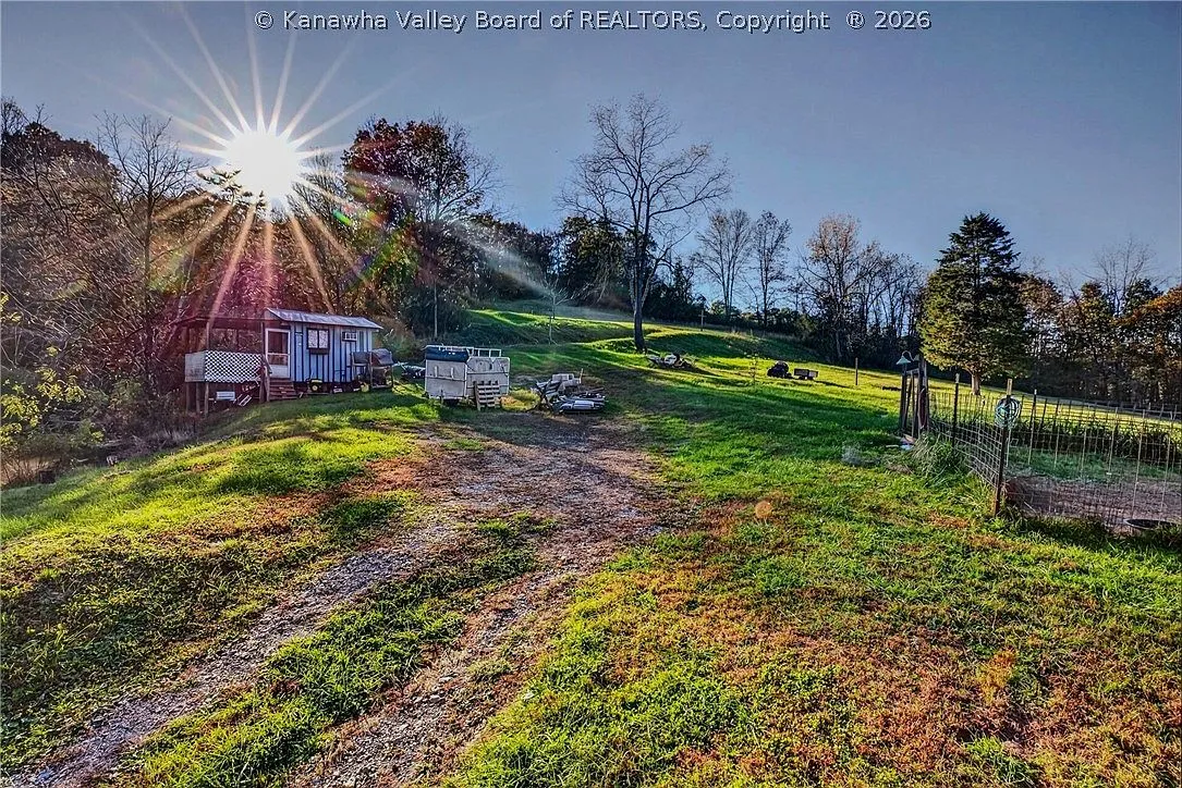 A gravel path leading toward a storage shed and garden plot