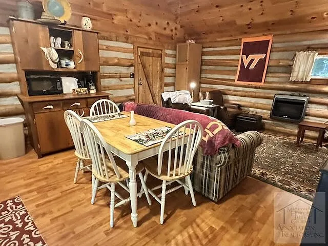 The dining table by the window with the kitchen behind
