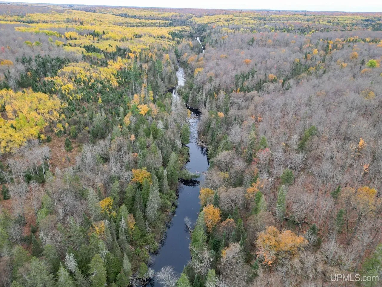 Aerial along the Fence River winding through the autumn woods