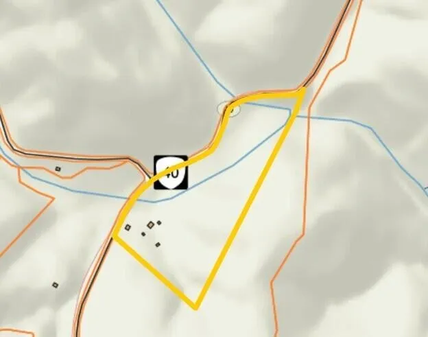 The county parcel map with the tract outlined in yellow along the highway and the creek