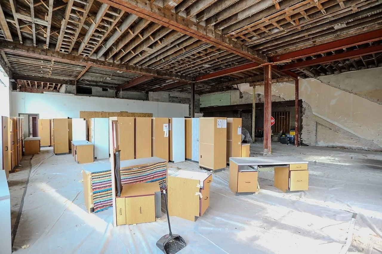 Office cabinets stacked on plastic sheeting under the open joists