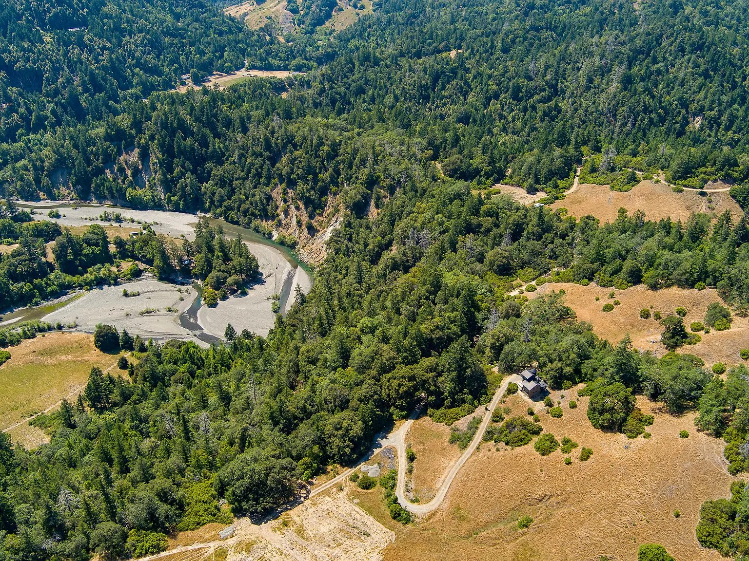 An aerial view of the river corridor and gravel bars cutting through the forested hills