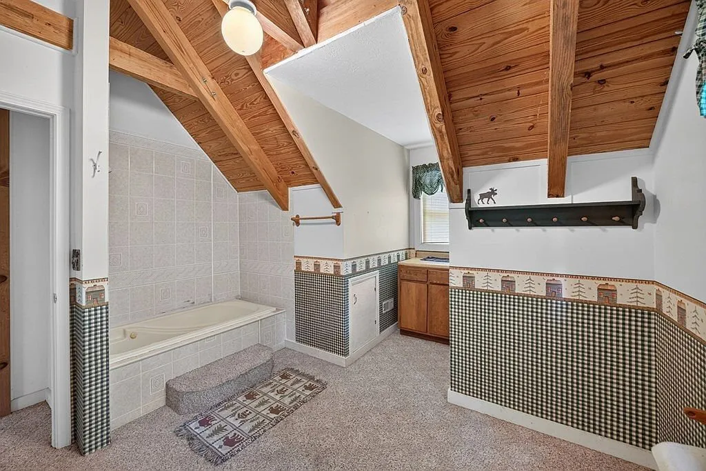 A utility room with beamed ceiling and a decorative plaid curtain