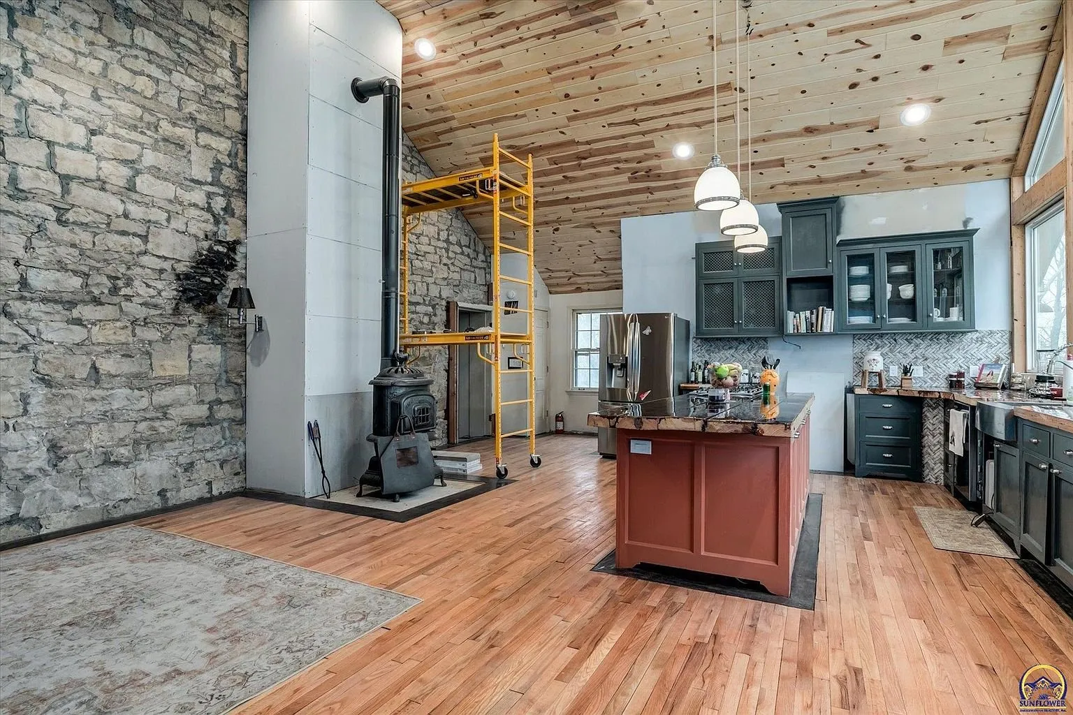 The kitchen and the stove from the far side with scaffolding by the stone wall