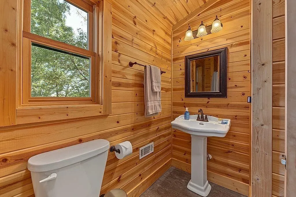 A bathroom sink and mirror with a window above