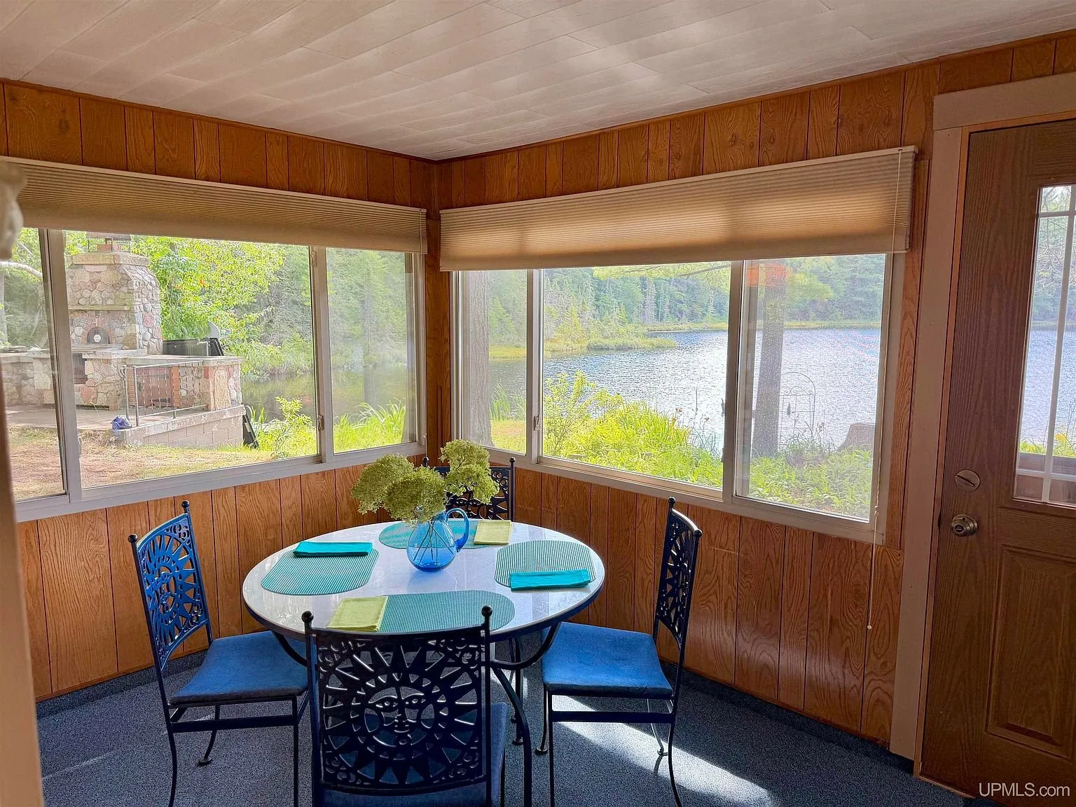 The three-season room table with the lake through the windows
