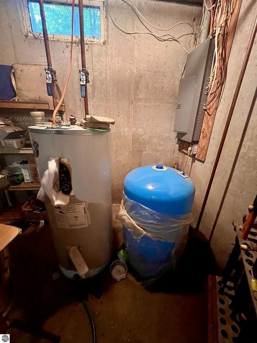 The basement utility corner with the water heater and the blue pressure tank
