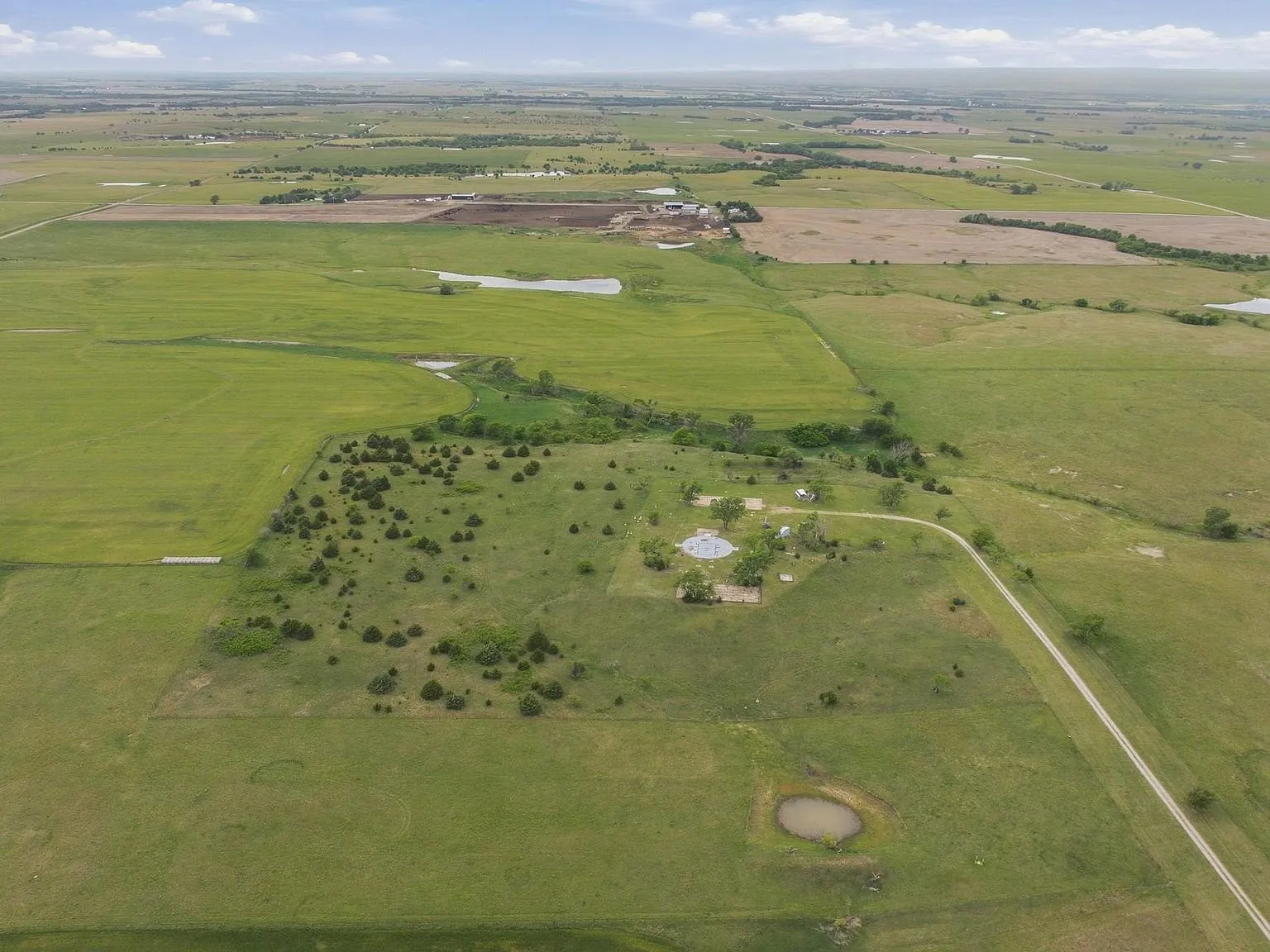 A wide aerial view of the surrounding farmland and open plains