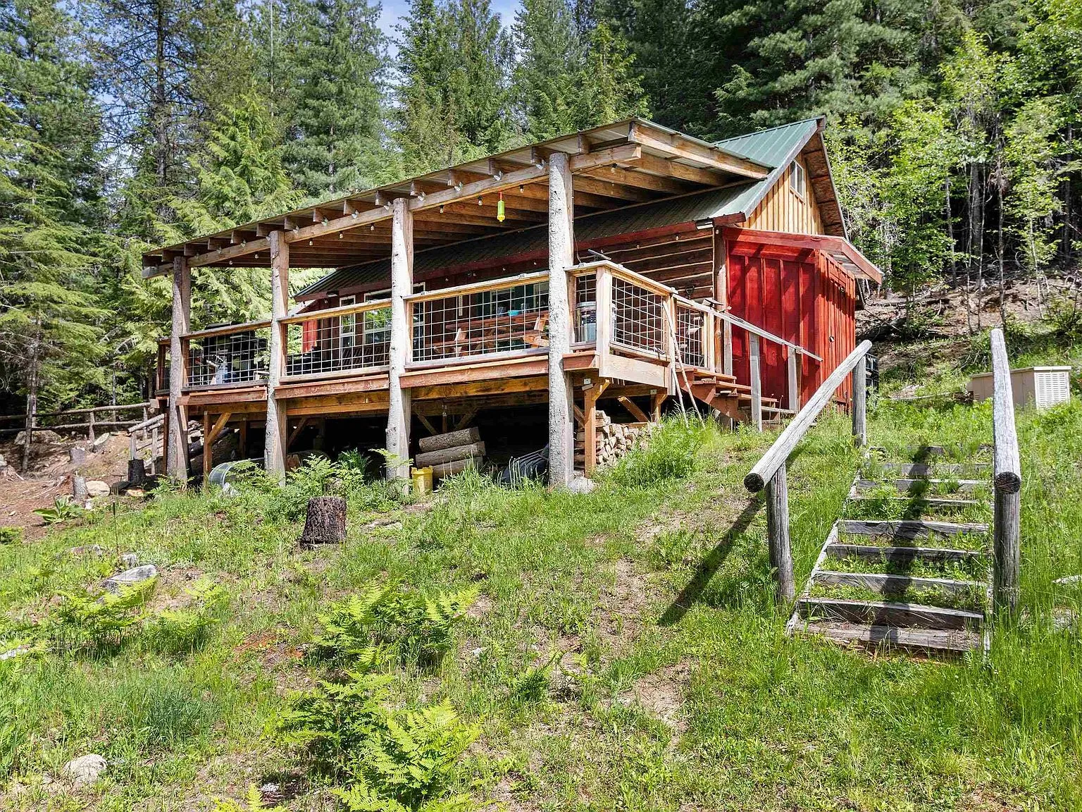 A cleared gathering area with a stone fire pit ring tucked among the pines