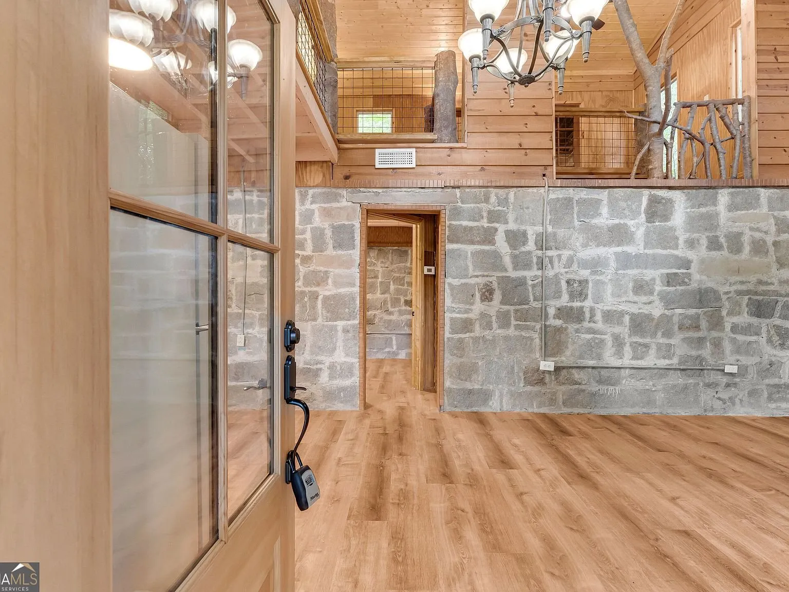 The open living area with a wood-clad ceiling and stone wall