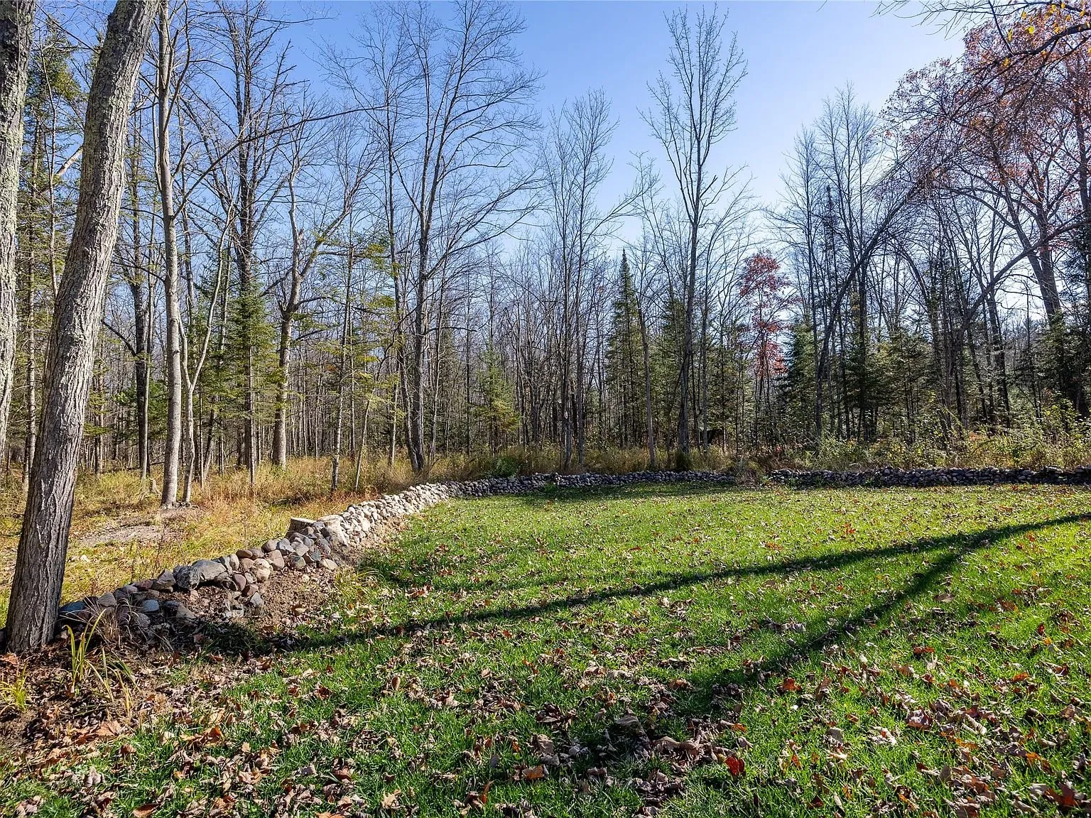A cleared section of the yard bordered by stacked stone