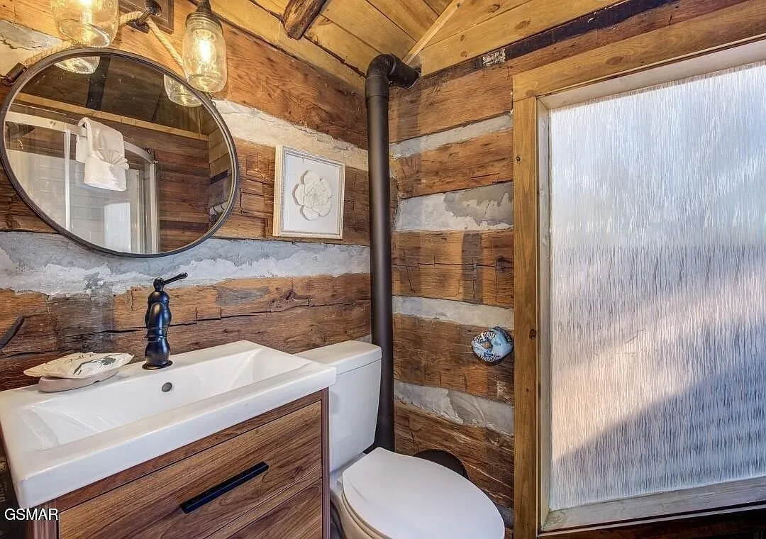 A half bath with a vessel sink under a round mirror