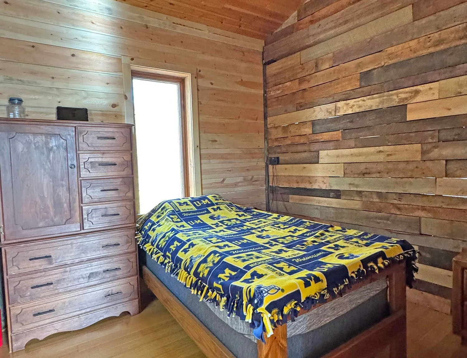 The main-floor bedroom with a bed against the plank wall