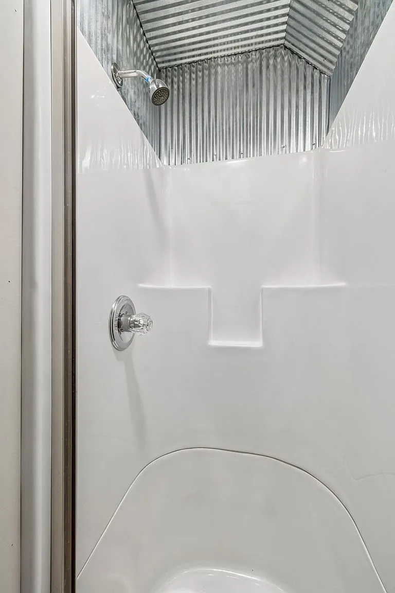 A shower stall with the tin ceiling
