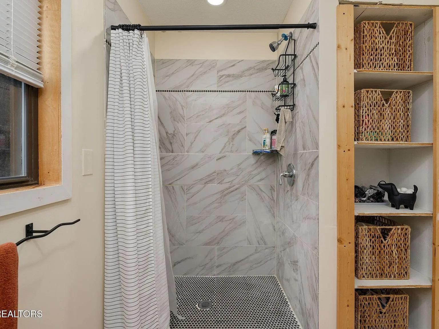 A bathroom vanity, mirror and toilet with tile accents