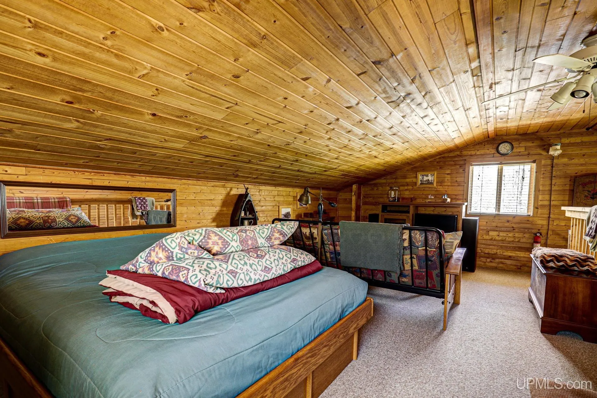 The bed in the loft with a window at the gable
