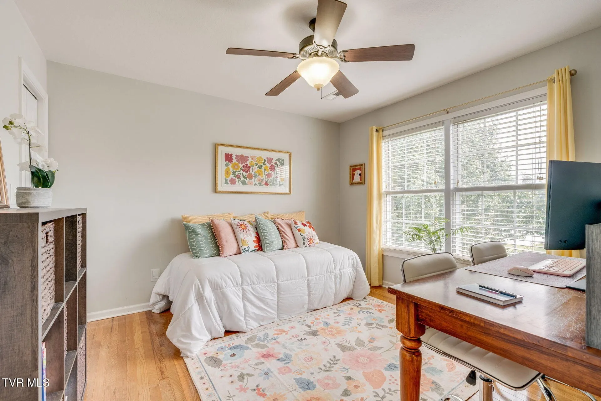 A second upstairs bedroom with a bed, desk and window