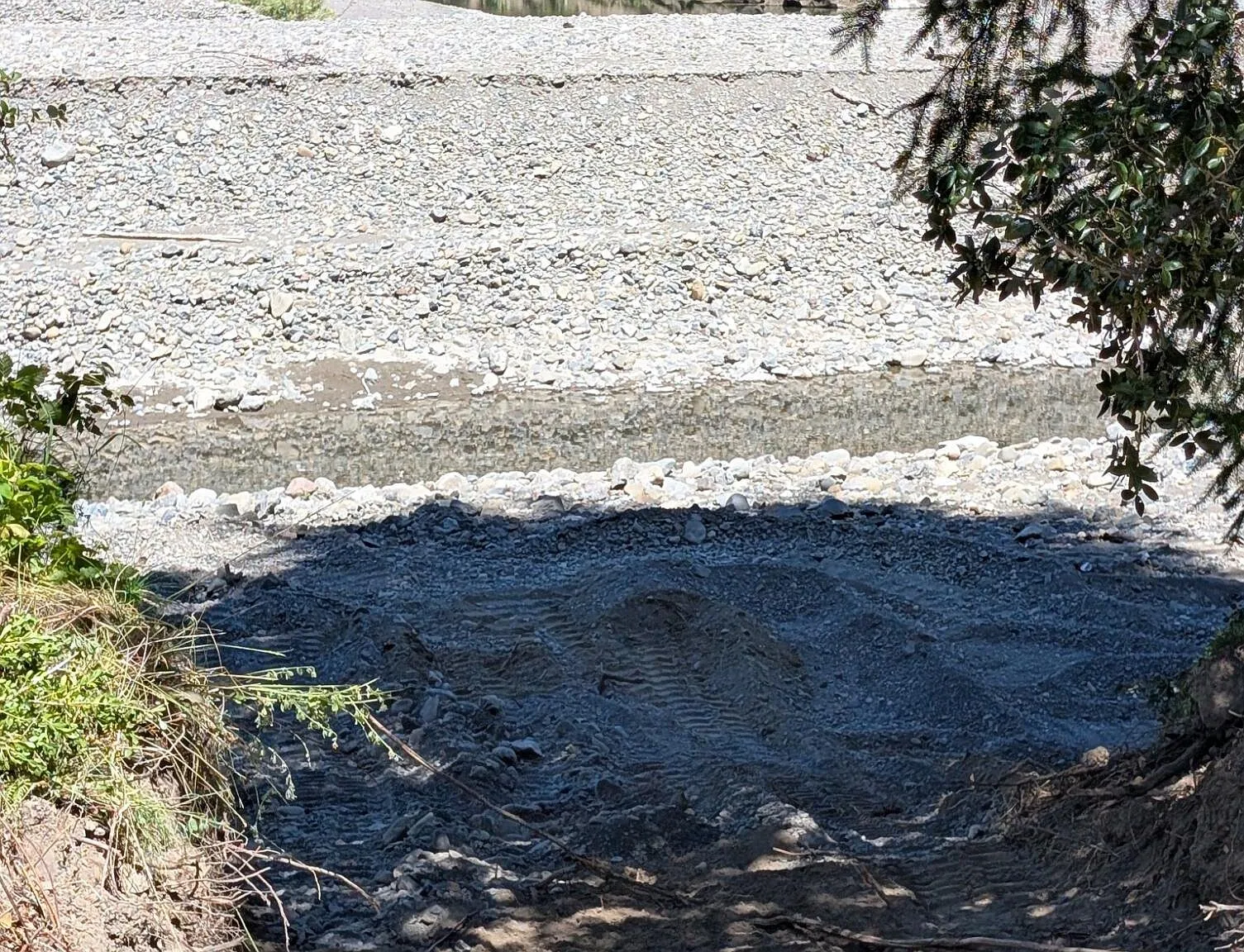 A close view of the clear creek water flowing over a gravel bar