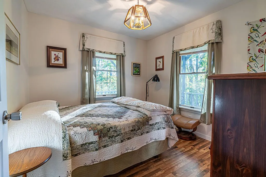A second view of the primary bedroom looking toward the porch-facing window