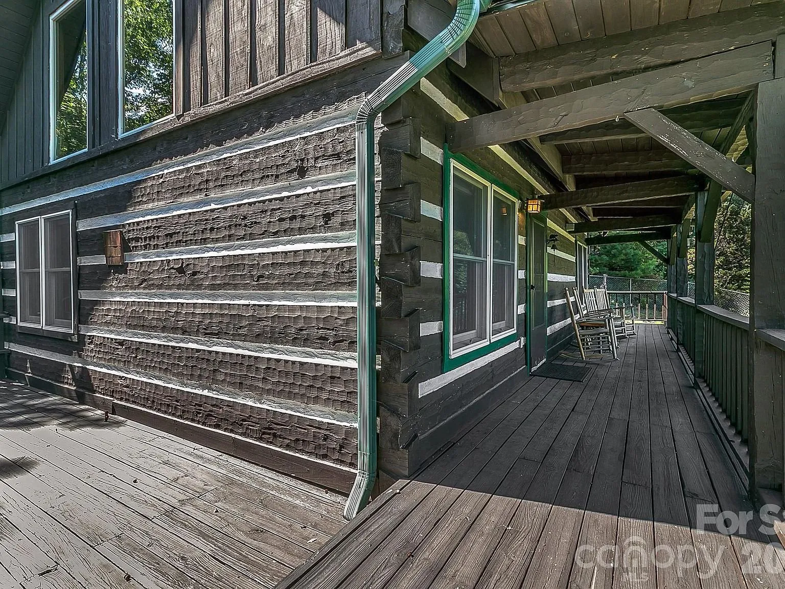 The log exterior and covered walkway along one side of the cabin