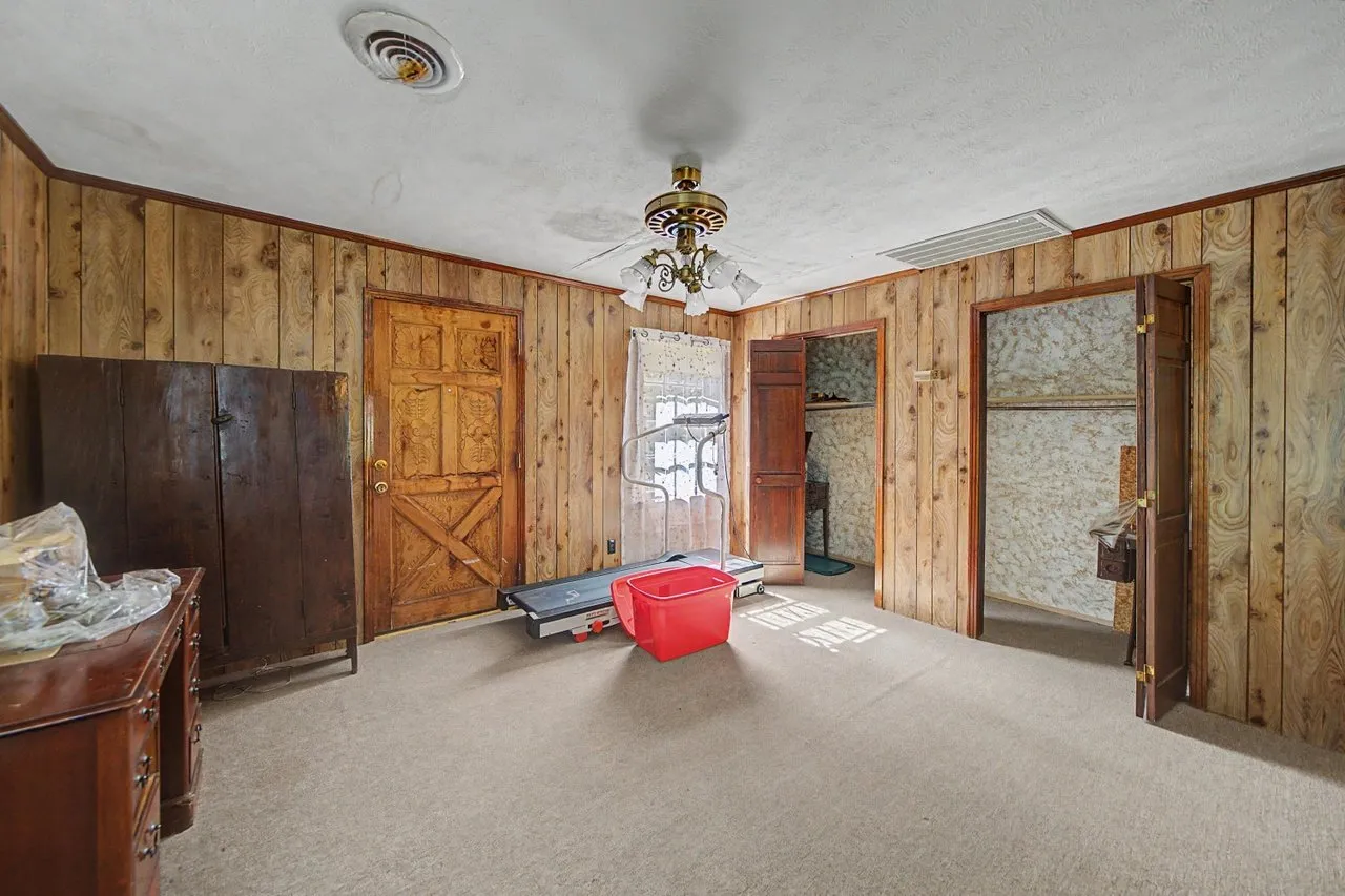 A panelled room with a wood door and boxes stacked to one side