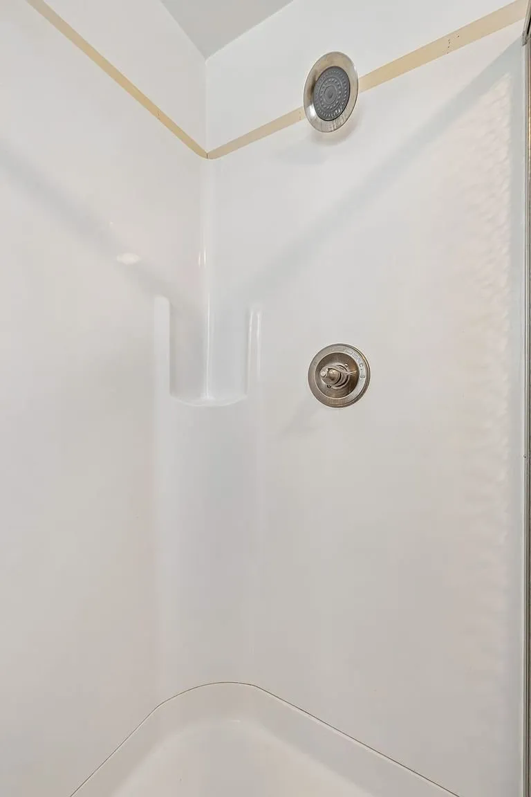 A shower stall with the fitting on the wall