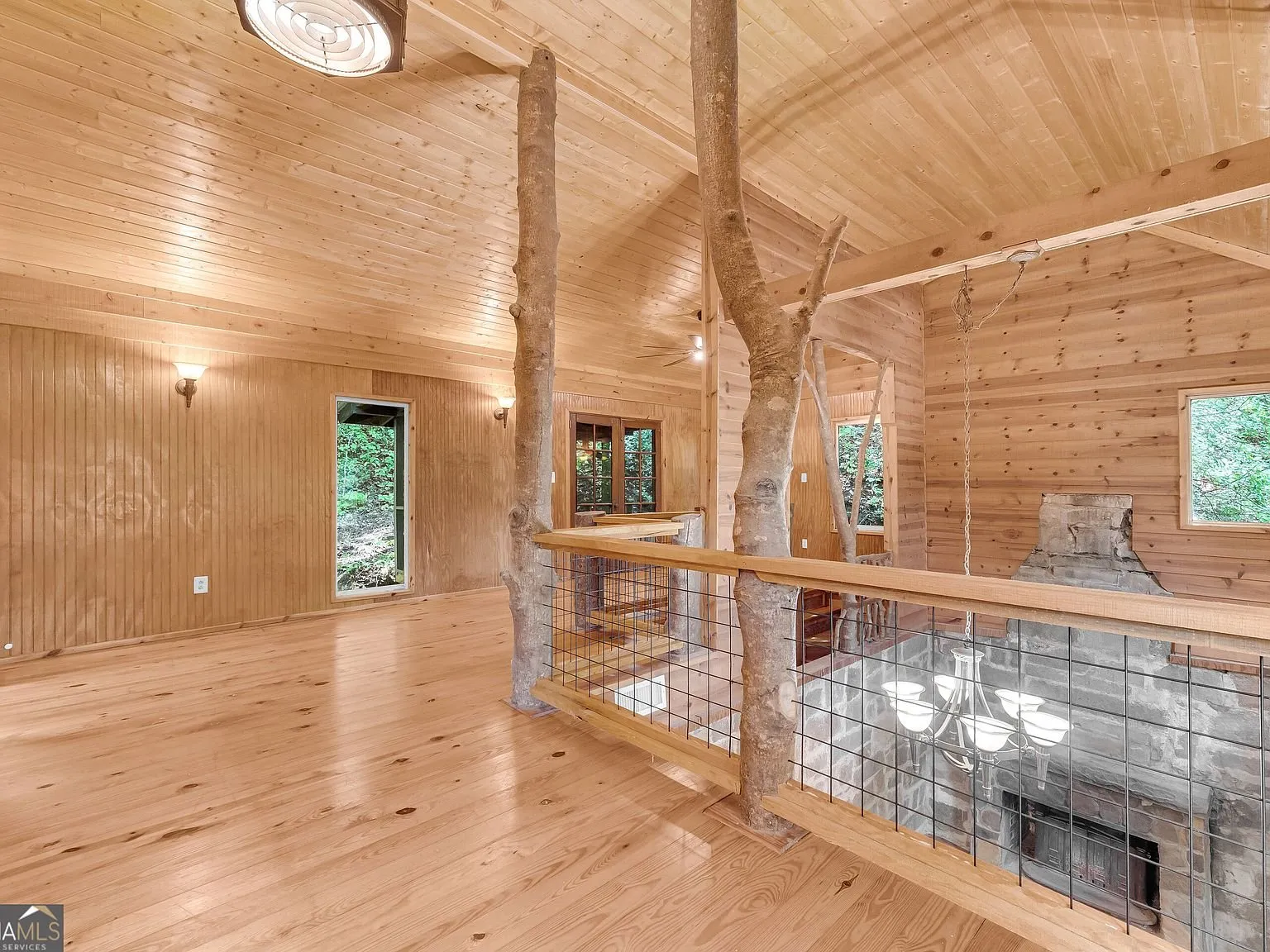 An empty wood-paneled room upstairs with natural light