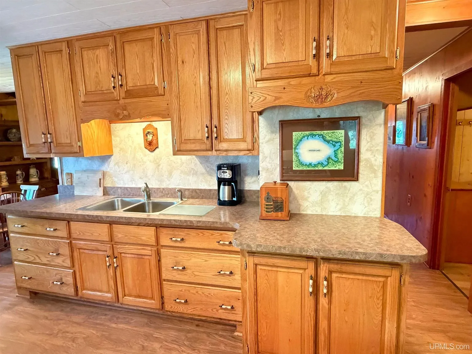The kitchen with oak cabinets and the sink under a stained glass panel