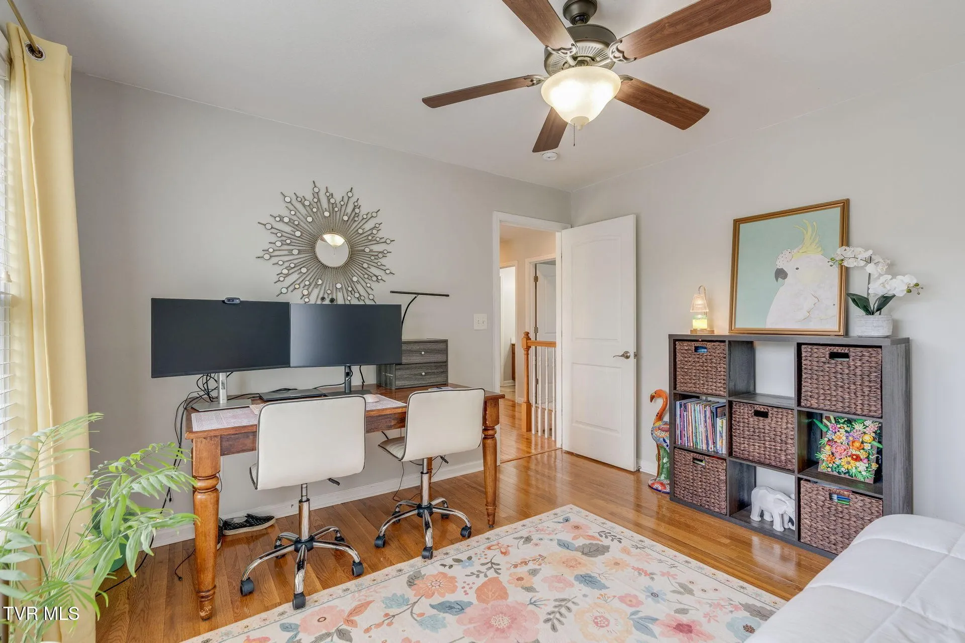 An upstairs bedroom set up as a sitting room with a television and shelving