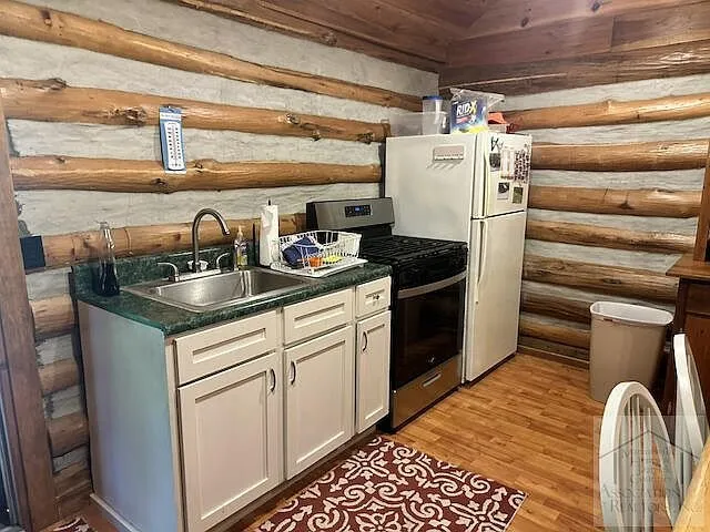 The kitchen with white cabinets, sink and gas range