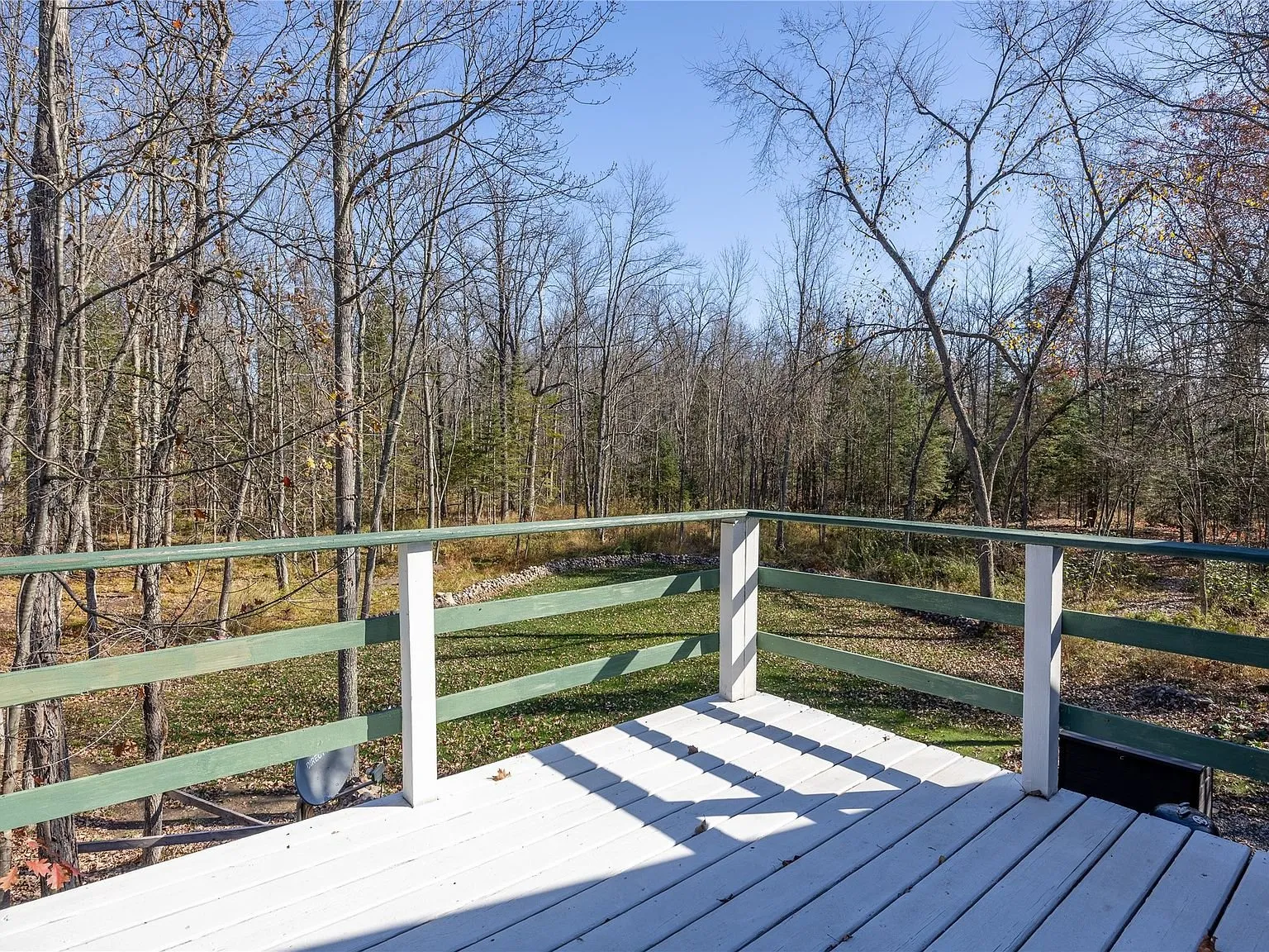 The view from the second-story deck over the wooded yard below