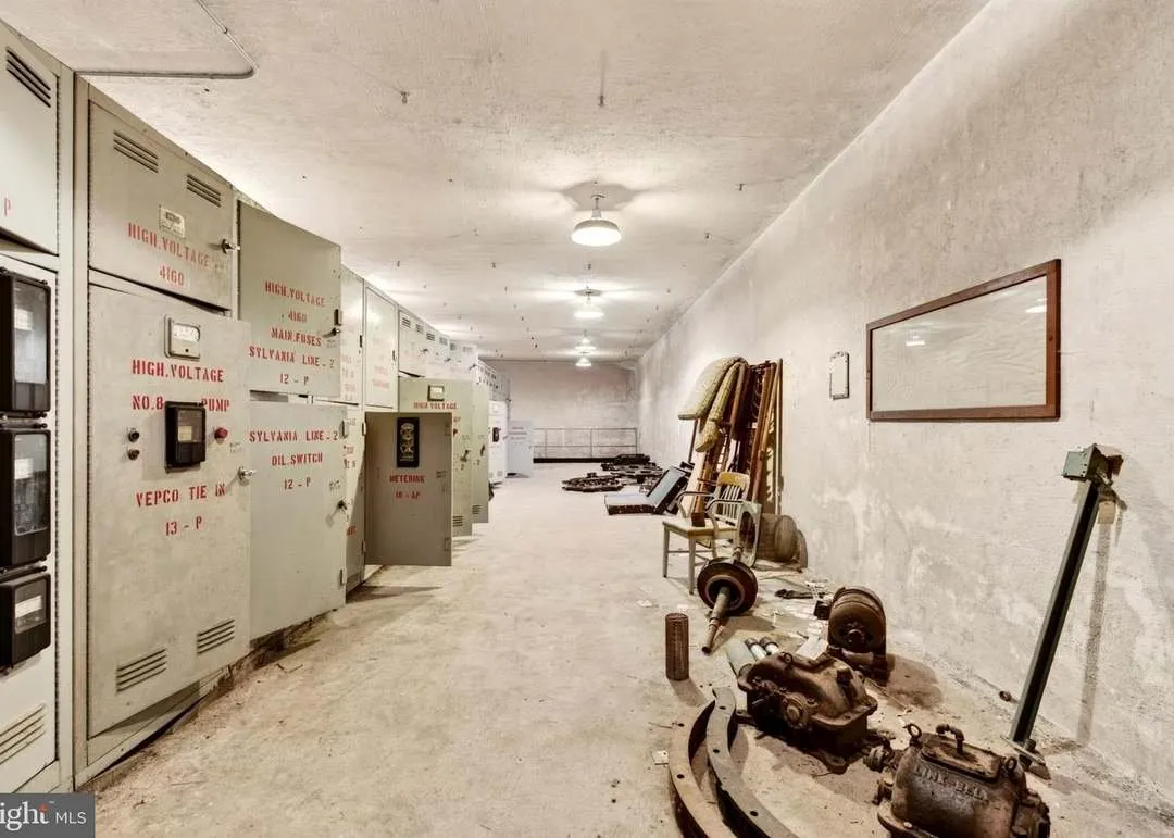 A basement hallway lined with electrical panels marked high voltage