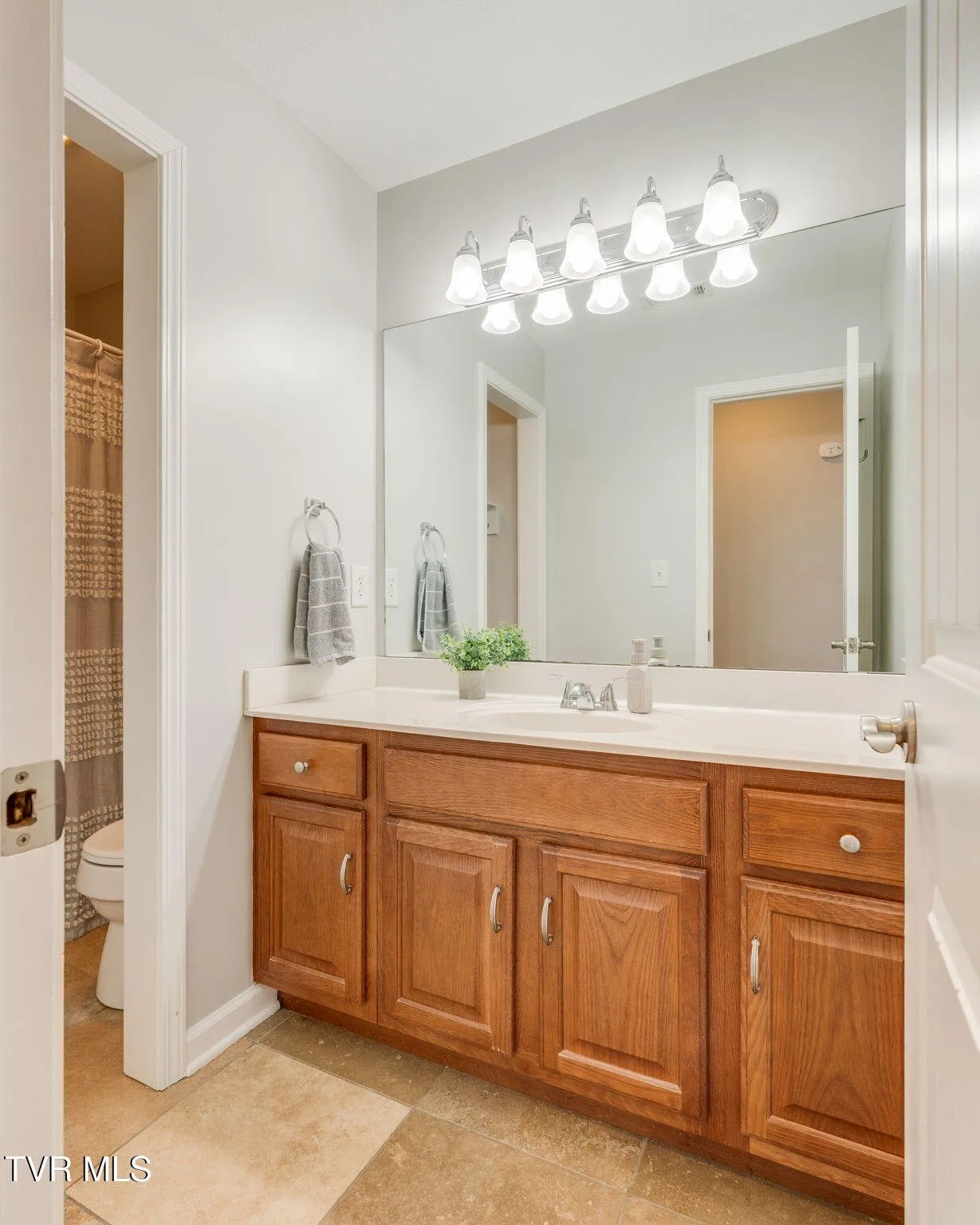 The second upstairs full bathroom with a vanity and framed mirror