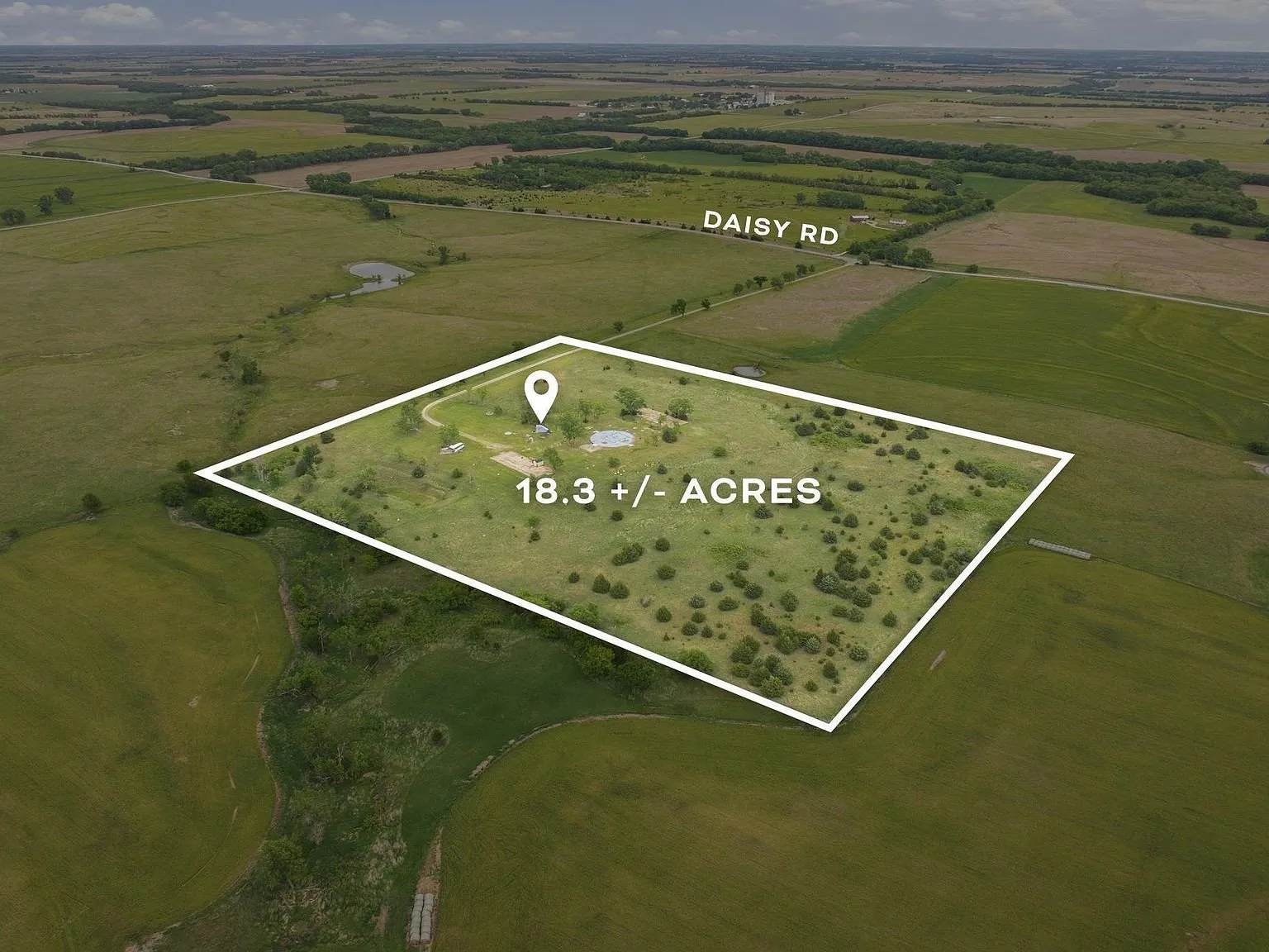 An aerial view with the property's approximately 18.3-acre boundary outlined, Daisy Road labeled alongside it