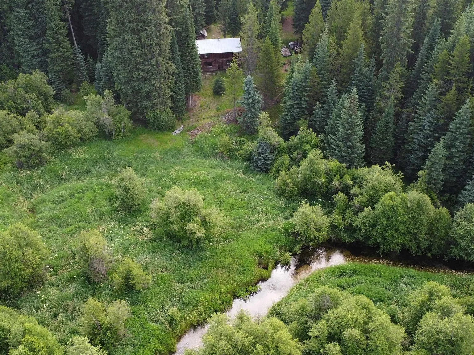 An aerial view of mountain ridgelines and open meadow near the property