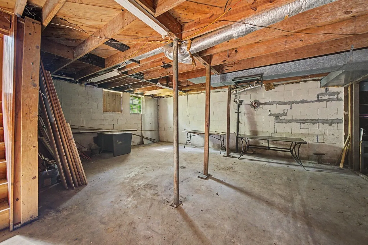 The unfinished basement, exposed joists and a support post