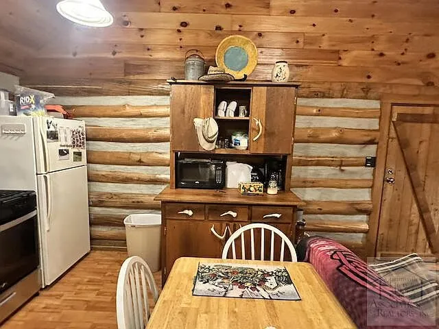 The kitchen hutch, refrigerator and dining table