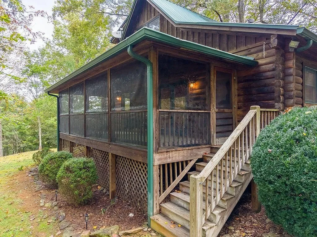 The cabin's rear exterior with the screened porch and stairs to the yard