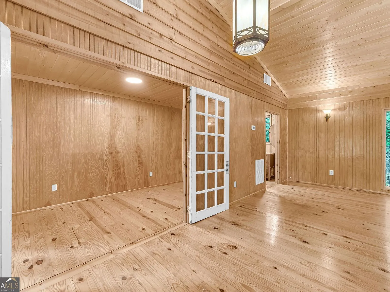A second empty wood-paneled room upstairs