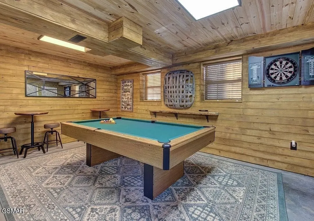 The game room with a pool table, dart board and a card table
