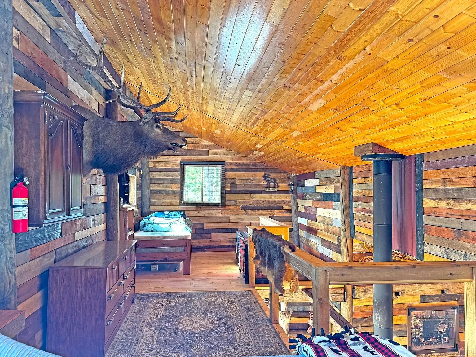 The loft from the stair head, stove pipe running up through the room