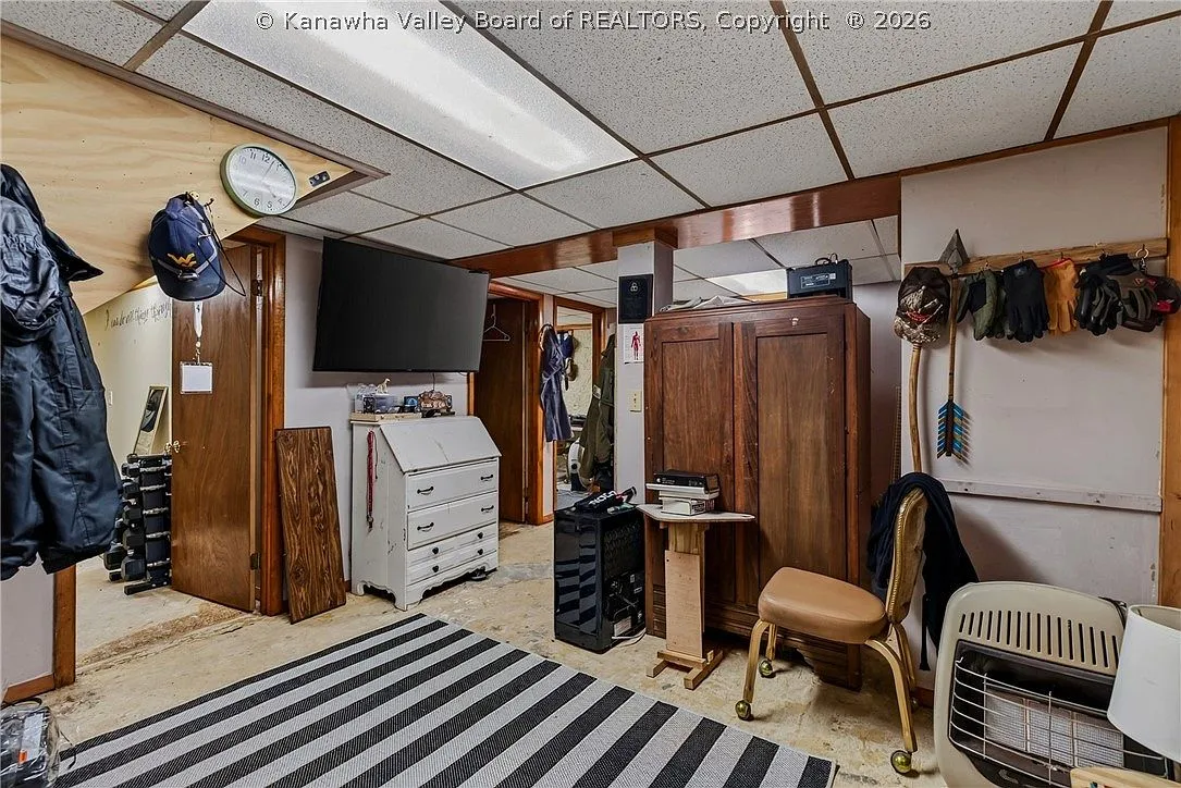 A finished basement room with a wall-mounted TV and wood wardrobe