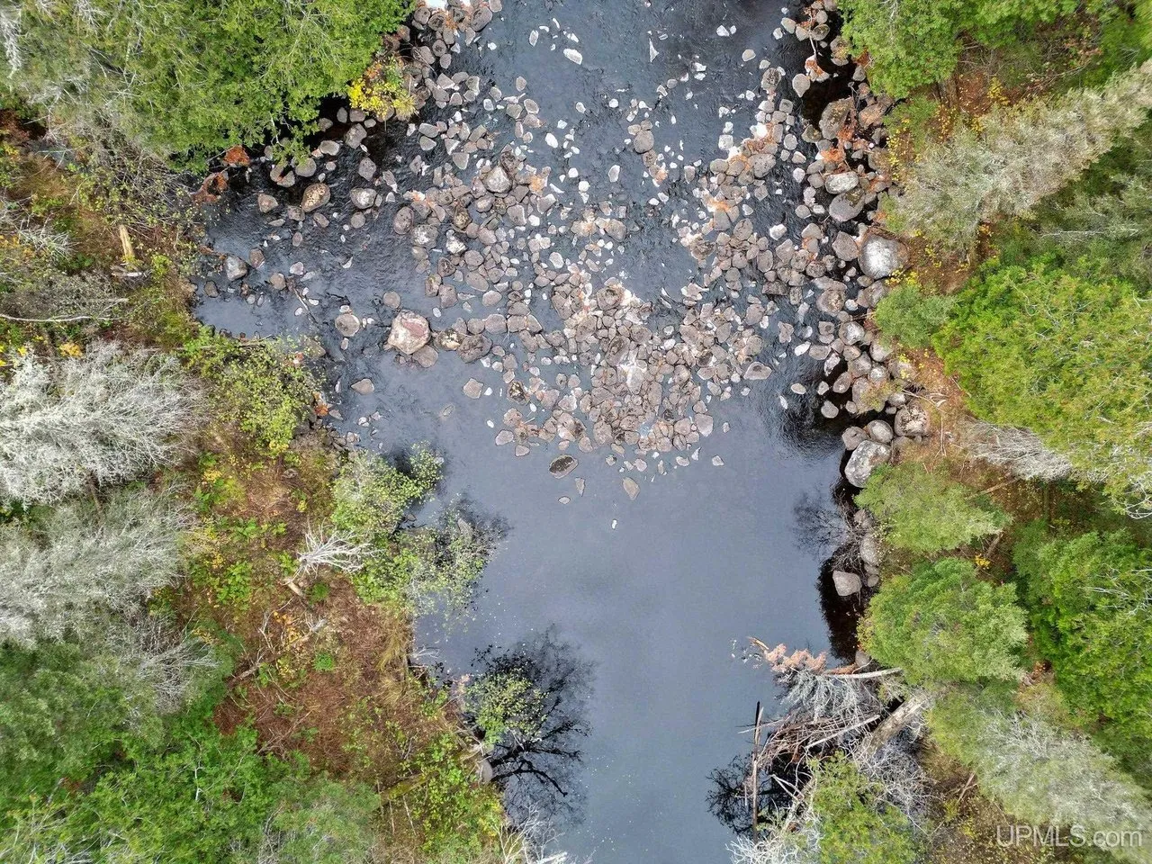 A rocky stretch of the river from above, boulders breaking the surface