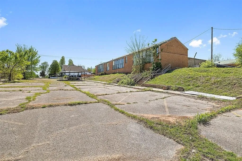 The cracked concrete play yard behind the school