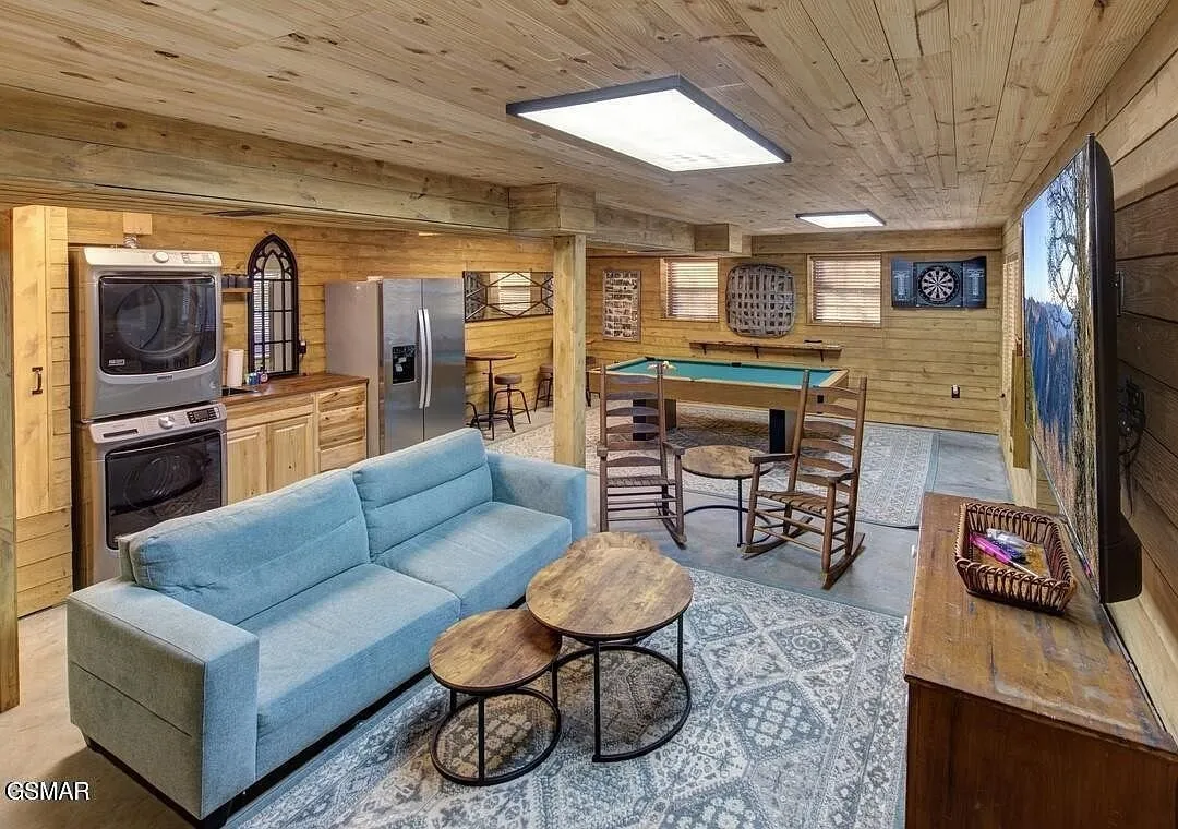 The lower level sitting area with a sofa, television and a bar counter