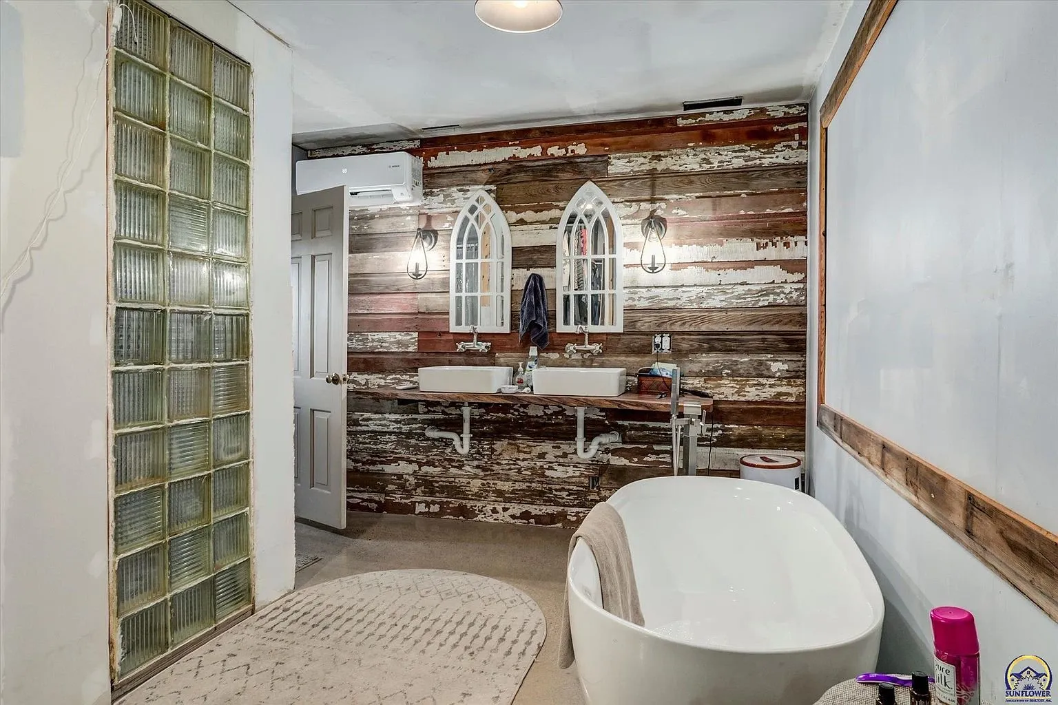 The primary bath with the soaking tub, the double sinks and the arched mirrors
