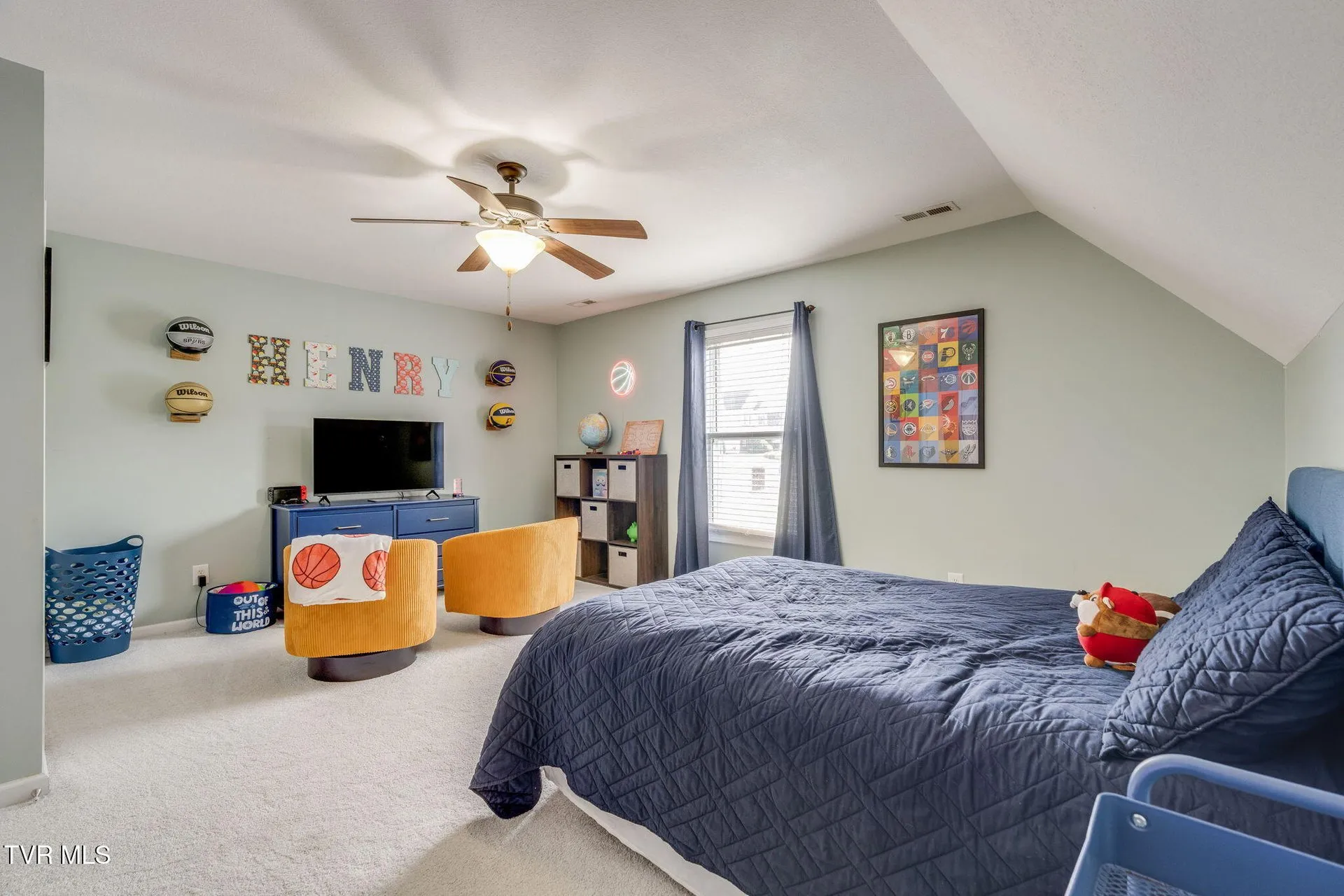 A bedroom with a bed, wall art and a ceiling fan